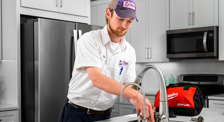 Blanton's service professional fixing a kitchen sink in a NC home
