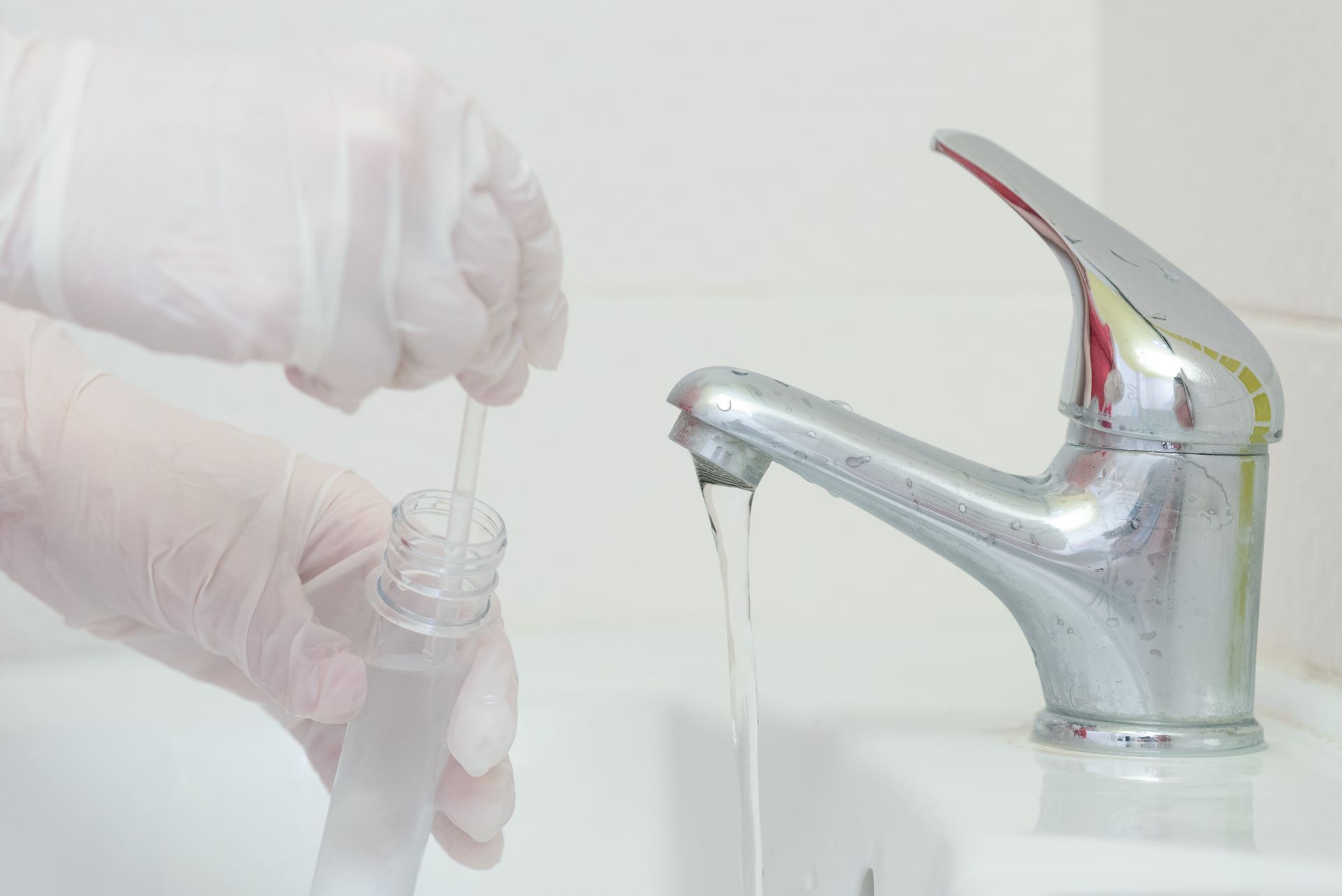 Professional water testing being done by a plumber using a residential faucet